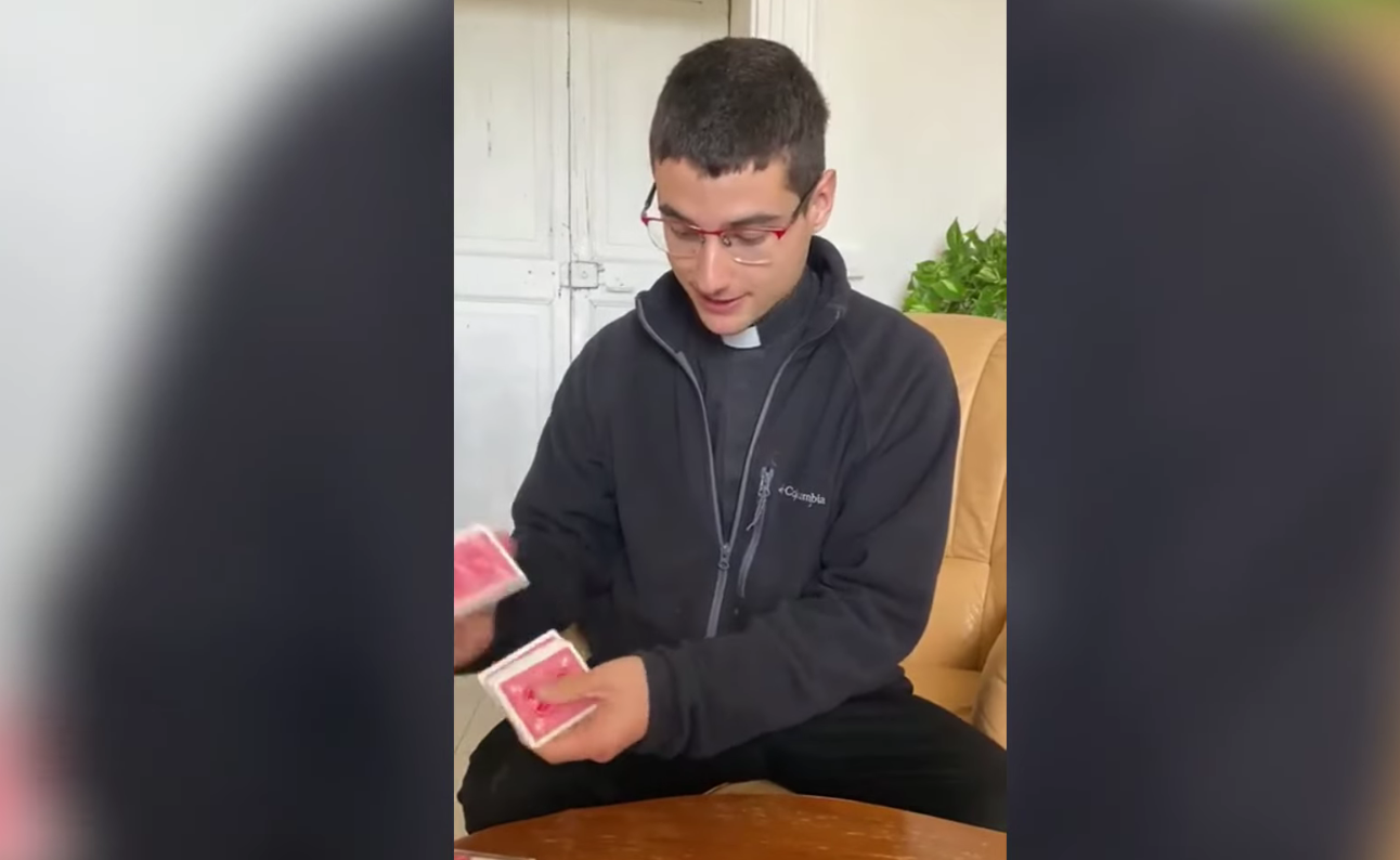 Le jeune Raúl Chasco Gonzalez, assis près d'une table basse, bat son jeu de carte.