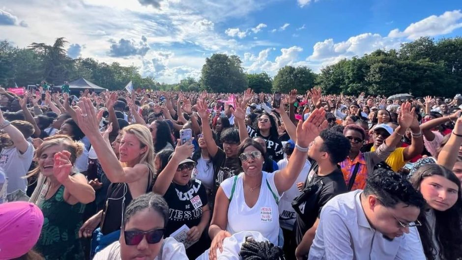 Des personnes d'une foule qui s'étend à perte de vue lève une main durant la Marche pour Jésus