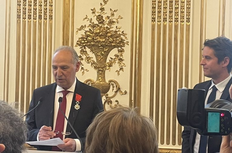 René Léonian arbore la médaille de la Légion d'honneur sur sa veste aux côtés du Premier ministre Gabriel Attal