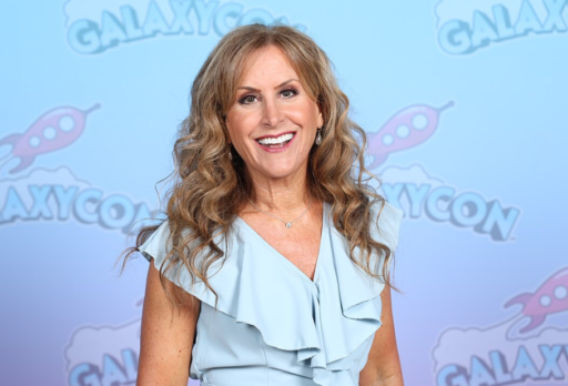 Jodi benson, la soixantaine, pose en souriant en regardant vers l'objectif. Elle a de long cheveux ondulés.