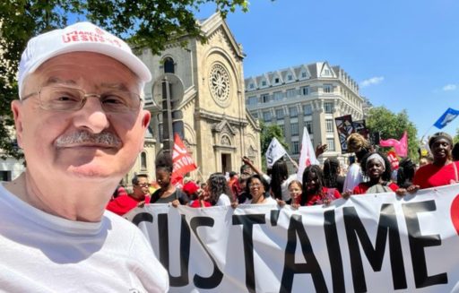 Gilbert Leonian prend un selfie devant le défilé de la Marche pour Jésus et une banderole "Jésus t'aime"